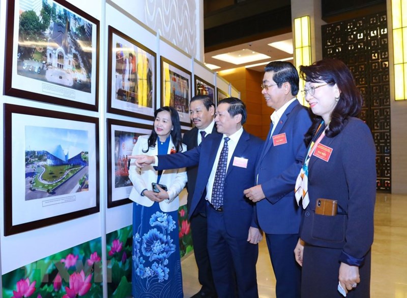 Các đại biểu tham quan triển lãm ảnh được trưng bày tại hội nghị. (Ảnh: TTXVN)